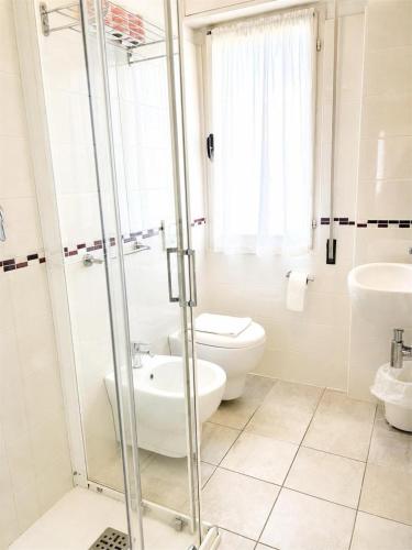 a white bathroom with a toilet and a sink at Hotel Degli Angeli Riccione in Riccione