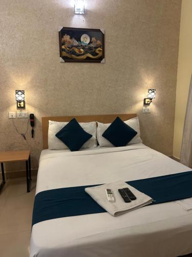 a hotel room with a large bed with blue pillows at Crayons Hotel in Chennai