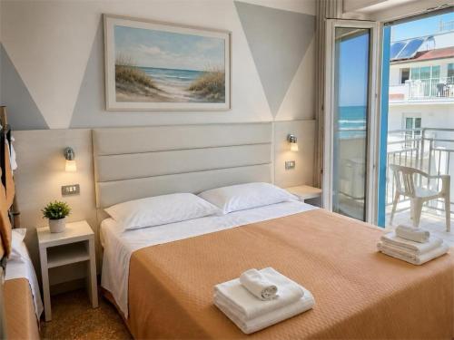 a bedroom with a bed with two towels on it at Hotel Degli Angeli Riccione in Riccione