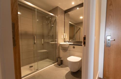a bathroom with a shower and a toilet and a sink at Ramsey Park Hotel in Ramsey