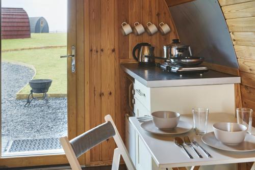 a small kitchen with a table with two cups on it at Iona Pods in Iona