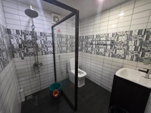 a bathroom with a shower and a toilet and a sink at Backwater Breeze in Kumarakom