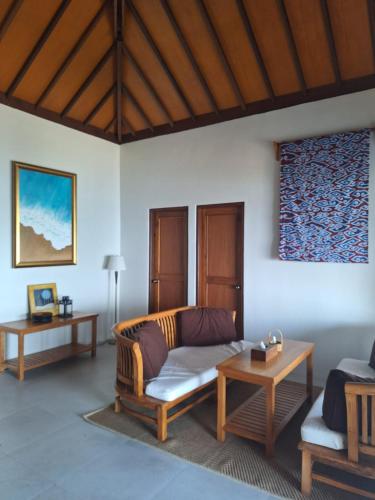 a living room with a couch and a table at Legon Waru Cottage in Karimunjawa