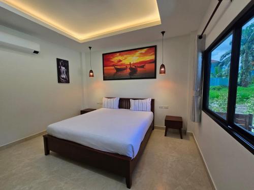 a bedroom with a bed and a large window at Palm Garden Villa Aonang in Ao Nam Mao