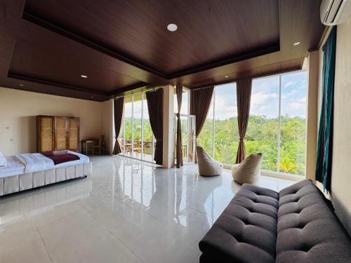 a bedroom with a bed and a couch and windows at Nona Lodge in Tetebatu