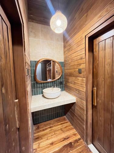a bathroom with a sink and a mirror at Wavedance Bali Surfhouse in Airsatang