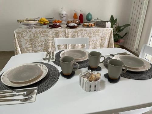 a white table with plates and utensils on it at Le 2 vele in Cerfignano