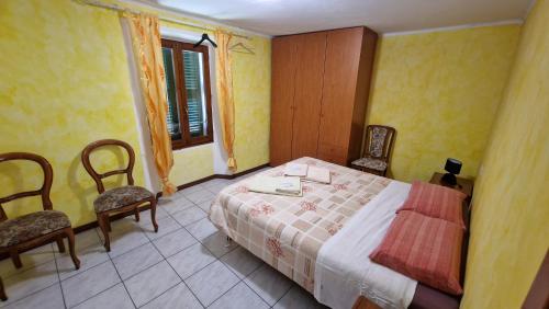 a bedroom with a bed and two chairs and a window at casa Belvedere in San Siro