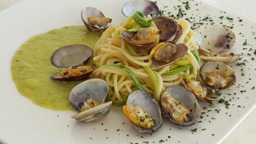 a plate of pasta with clams and mushrooms at Hotel Regina in Alassio