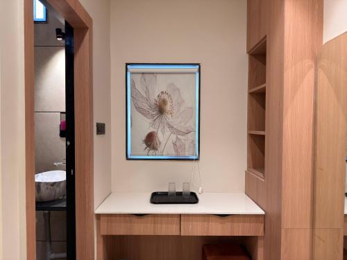 a bathroom with a picture of a flower on the wall at Hotel Shree Maya Comfort Inn in Ujjain