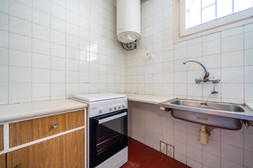 a kitchen with a sink and a stove at Lamoga Ona in Torredembarra