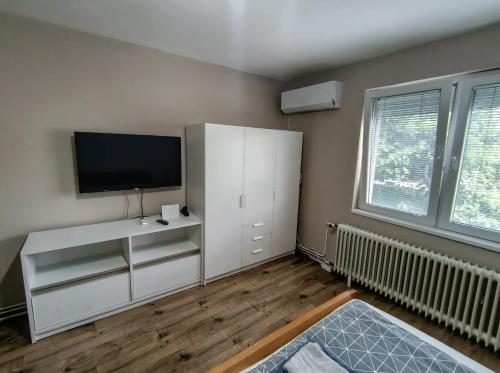 a living room with a white cabinet and a flat screen tv at Apartman Meridian in Zaječar