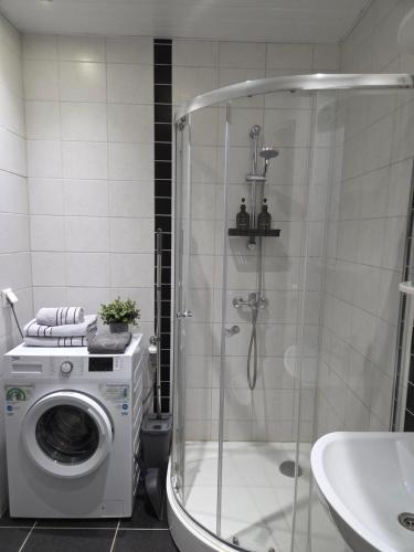 a bathroom with a shower and a washing machine at Küti apartments in Rakvere