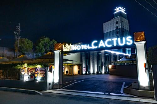 ein Gebäude mit einem Schild, auf dem nachts „ganzheitlich“ steht in der Unterkunft HOTEL the CACTUS in Kasugai