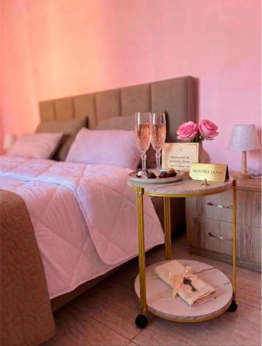 a bed with two tables with glasses of wine at Room 357 in Tirana