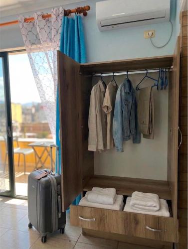 a walk in closet with a suitcase and clothes at Room 357 in Tirana