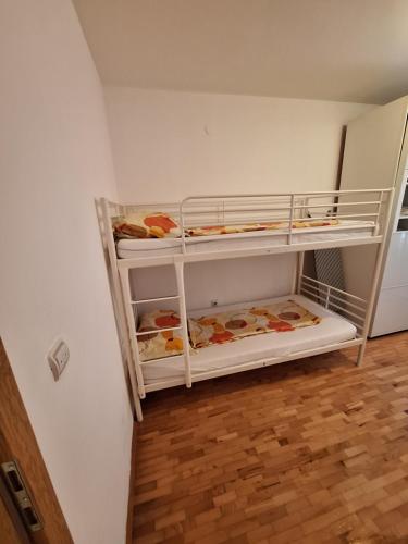 two bunk beds in a room with a wooden floor at Stan Foča in Foča