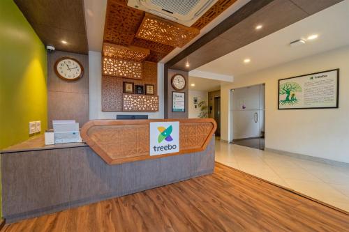 a hotel lobby with a reception desk and a clock at Treebo Premium Lavender Kochi Infopark in Cochin