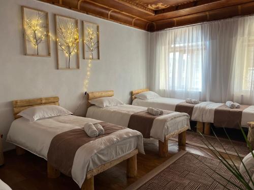 a room with four beds in a room at Crown Inn & Spa in Karakol