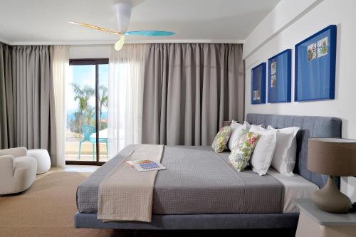 a bedroom with a bed with a view of a patio at Althea Resort in Áno Loutrón