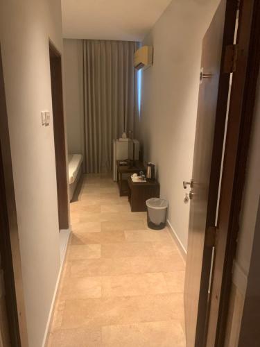 a hallway to a bathroom with a toilet in a room at Hotel room in Salalah