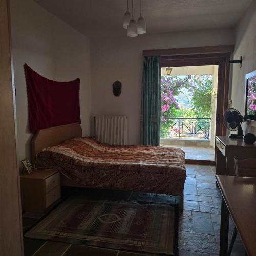 a bedroom with a bed and a large window at Marmari Sunset View in Marmari