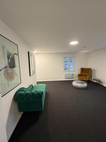 a living room with a green couch and a chair at Bartenwetzer Schleusenhaus 1 in Melsungen
