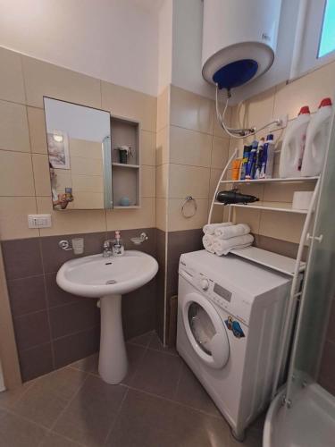 a small bathroom with a washing machine and a sink at Mimosa Apartment in Vlorë