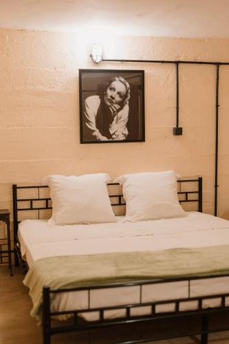 a bedroom with two beds and a picture on the wall at Le Bunker Secret - Logement Insolite in Florensac