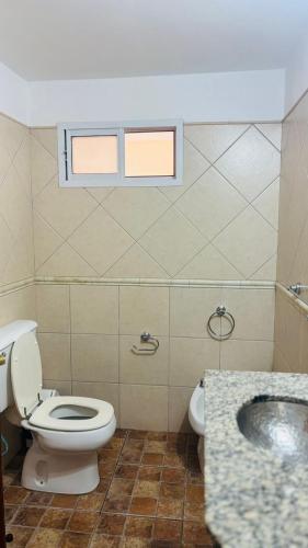 a bathroom with a toilet and a sink and a window at Hotel las ruedas by Choca in Arroyito