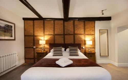 a bedroom with a large bed with two towels on it at The Talbot Hotel in Ledbury