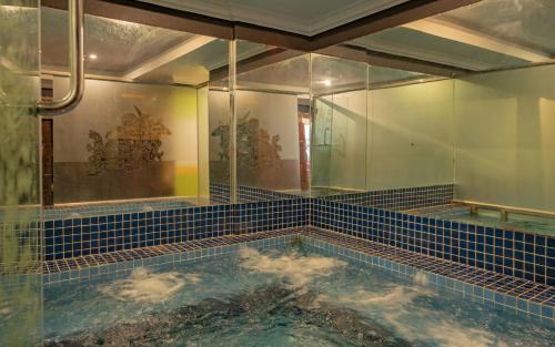 a bath room with a pool of water in a room at Somadevi Angkor Premium in Siem Reap