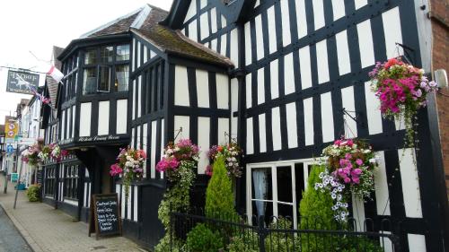 a black and white building with flowers in the windows at The Talbot Hotel in Ledbury