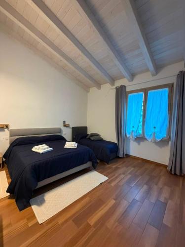 a bedroom with two beds and blue curtains at Domos de Budroni B&B in Bono