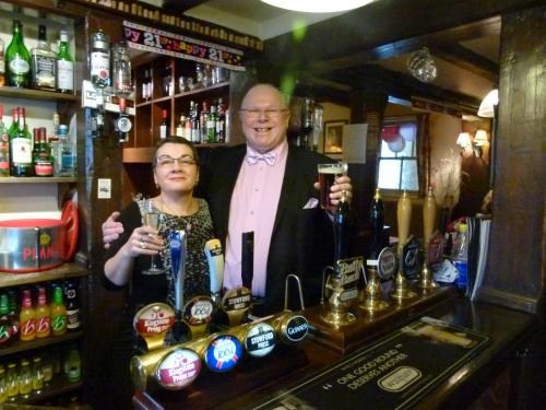 a man and a woman standing behind a bar at The Talbot Hotel in Ledbury