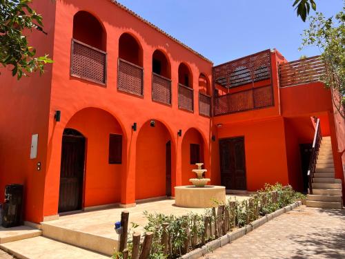 an orange building with a fountain in the courtyard at iBiZa Hostel in Beni Suef
