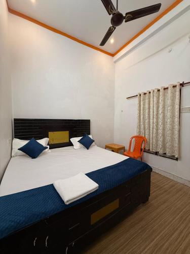 a bedroom with a large bed with blue pillows at Shri Raghuveer guest house in Ayodhya
