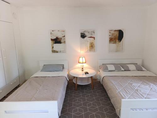 a room with two beds and a table with a lamp at VA vikendica Tesanj in Tešanj