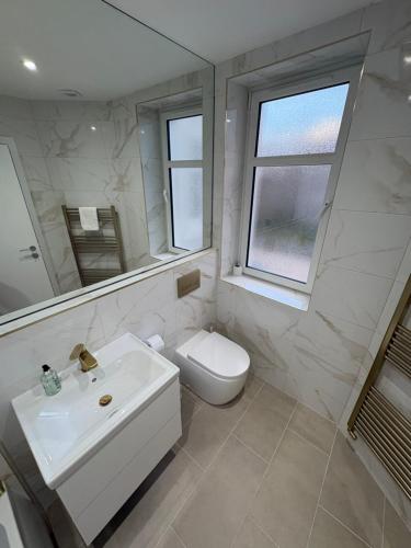 a white bathroom with a sink and a toilet at Skips in Largs