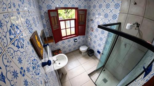 a bathroom with a toilet and a sink and a window at Nuh Hostel in Ouro Preto