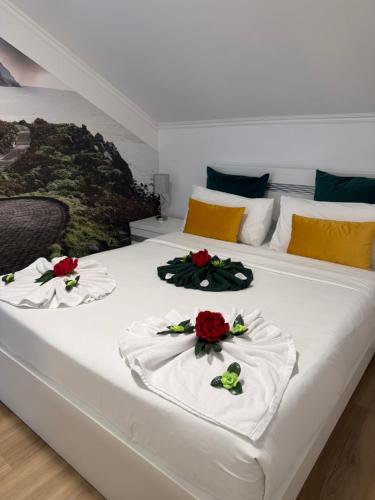 a bedroom with two beds with red roses on them at Palheiro dos 3 A`s in Achadas da Cruz