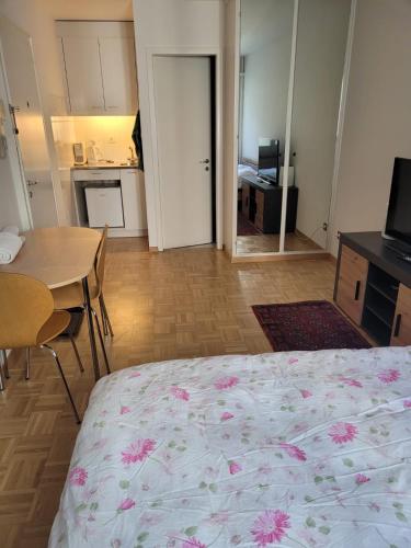 a bedroom with a bed and a table and a kitchen at 1 Flat-Room Bern in Bern