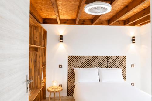 a bedroom with a white bed and a wooden ceiling at Le Cocon d'Ava - Bungalows & Spa in Saint-Paul