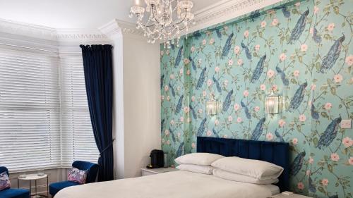 a bedroom with a bed with a floral wallpaper at The Rosedene in Llandudno