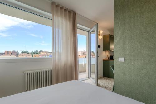 a bedroom with a bed and a large window at Marcello's Como Lake - Camerlata in Como