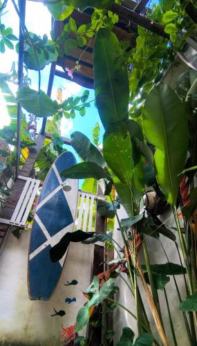 a surfboard sitting on the floor next to a plant at Villa Moura Pousada in Amontada