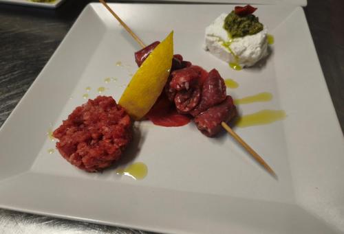 a plate of food with meat and a lemon on it at Hostaria Floow in Avigliana