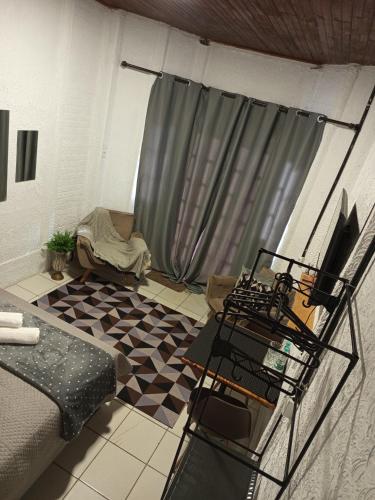 a living room with a couch and a table and a curtain at Suíte aconchego in Domingos Martins