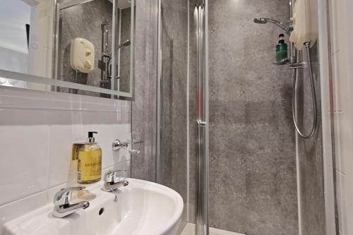 a bathroom with a sink and a shower at The Rosedene in Llandudno