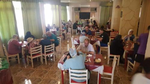a group of people sitting at tables in a restaurant at New Sandy Hotel in Marsa Matruh